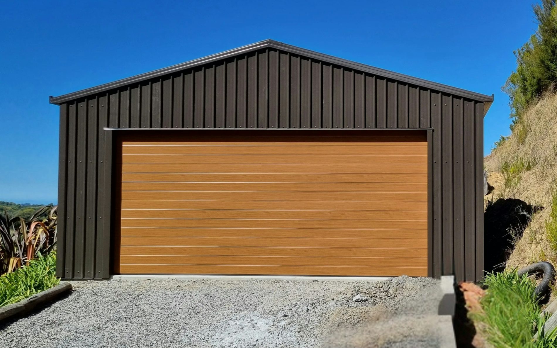 6.0m x 6.0m double garage, featuring 6-Rib Corrugate cladding in COLORSTEEL® Ironsand, paired with a NatureSteel door