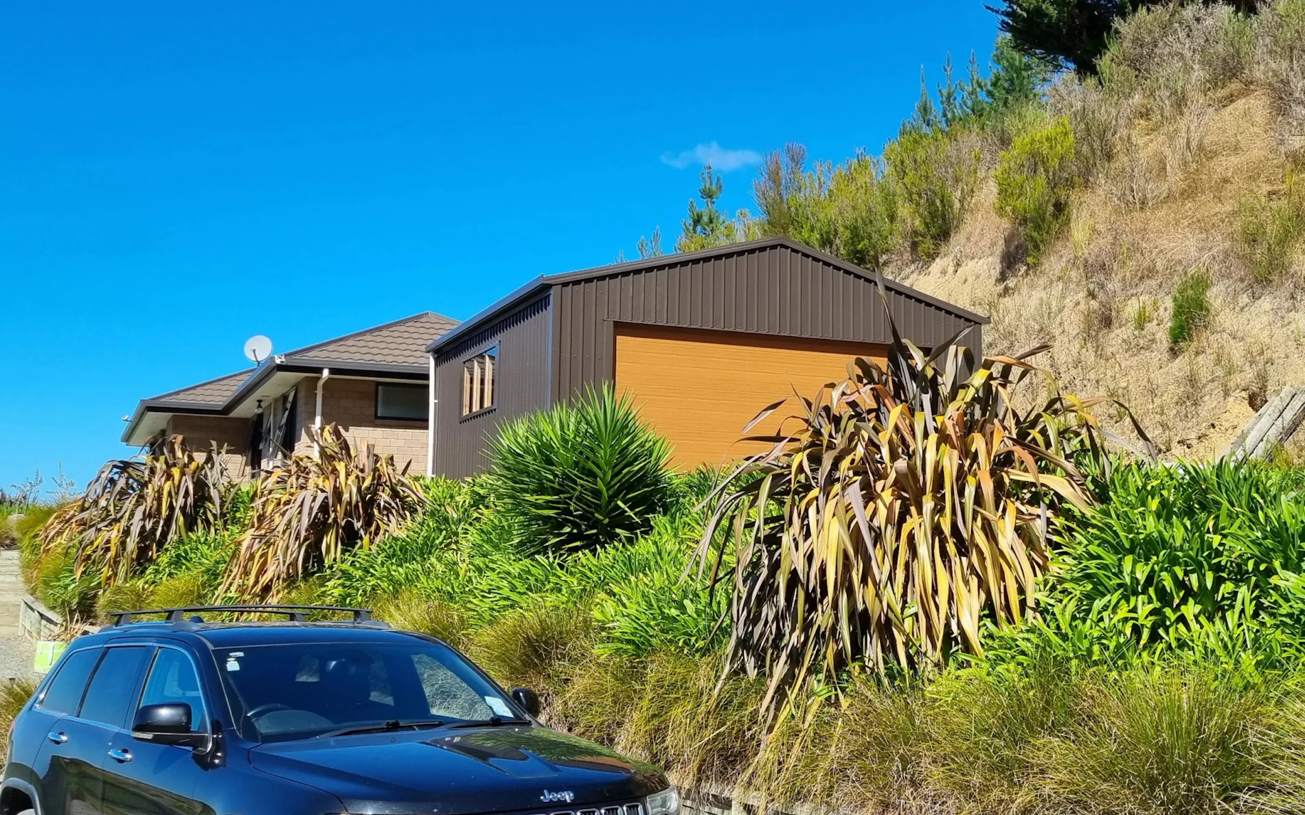 6.0m x 6.0m double garage, featuring 6-Rib Corrugate cladding in COLORSTEEL® Ironsand, paired with a NatureSteel door