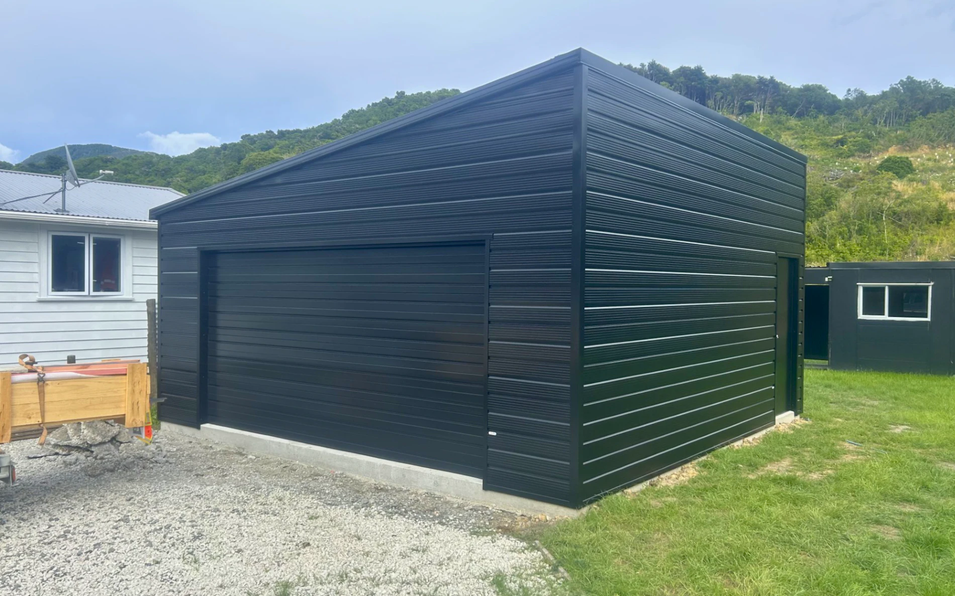 6.0m x 6.0m double garage with Mono pitch roof, featuring Superclad cladding in COLORSTEEL® Ebony