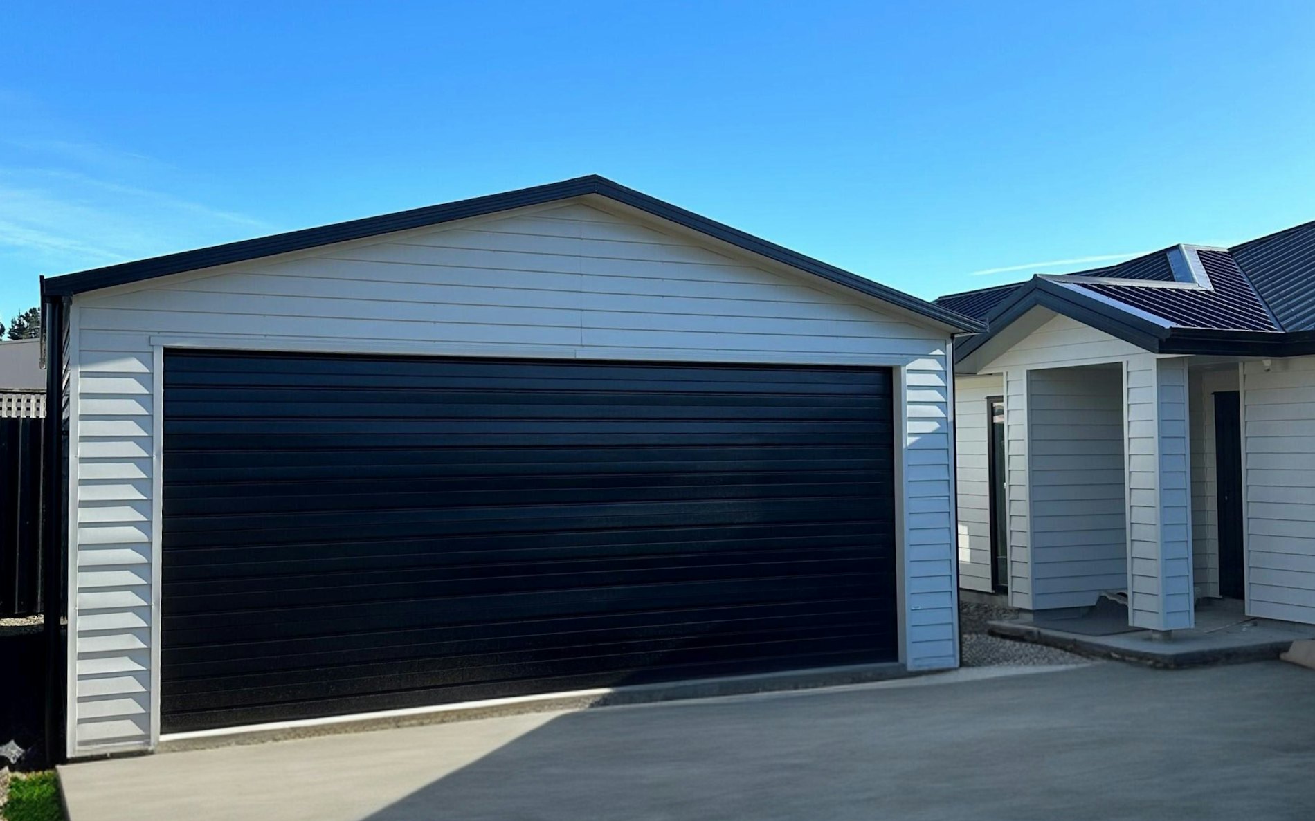 6m x 6m double garage, Versaclad cladding  in COLORSTEEL® Titania and Sectional door 5.1m wide Ebony